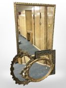 Three gilt mirrors and an embossed brass mirror,
