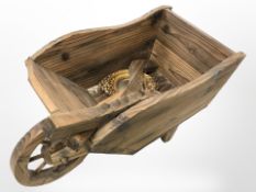 A small rustic pine wheelbarrow and a convex gilt mirror.