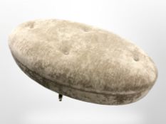 A contemporary oval stool on brass castors,