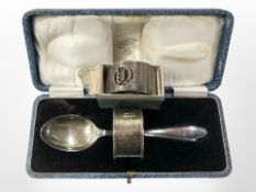 A cased silver spoon and napkin ring plus a further napkin ring.