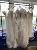 A rail of twelve wedding dresses, sizes 10 - 16,
