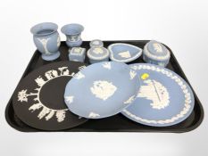 A group of Wedgwood blue and white Jasperware trinket boxes, dishes, similar plate on black ground,