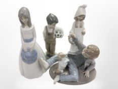 A Lladró figures of a girl, two Nao figures of boys, and a further Spanish figure, tallest 23cm.