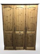 A modern pine triple door wardrobe,
