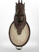 A contemporary carved tribal mask, length 51cm, and a feather twin-handled serving tray.