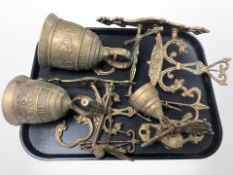 Three ornate brass bells with brackets.