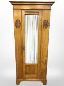 An Edwardian satin wood single door wardrobe,
