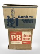 A Sankyo Dualux 1000 projector, and a Eumig P8 projector, both in boxes.