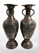 A pair of Japanese Meiji Period (1868-1912) cast-bronze twin-handled vases depicting dragons in