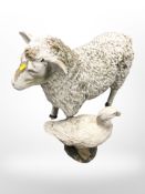 A plastic figure of a sheep and a duck,