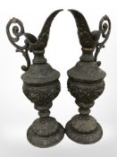 A pair of ornate patinated metal ewers, height 39cm.