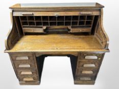 A 1930's oak tambour fronted twin pedestal desk,