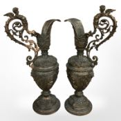 A pair of ornate patinated metal ewers, height 52cm.