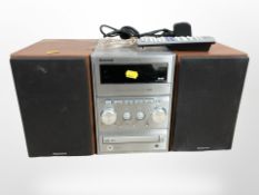 A Panasonic CD stereo system SA-PMX1DB, with speakers and remote.