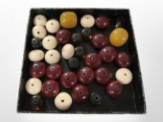 A group of loose turned bone and polished amber colour beads.