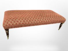 A Victorian style rectangular footstool on brass castors,