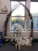 An artificial floral bridal arch and trees