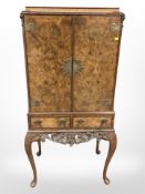 A carved walnut double door drinks cabinet,