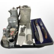 A hammered pewter teapot, sugar pot and two further sifters, pair of silver-handled cake slices,