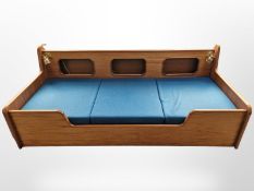 A 20th century Danish teak day bed with turquoise cushions,
