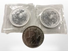 Three Britannia fine silver one-ounce coins, 1999 (x2) and 2000.