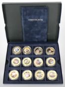 A group of 12 Queen Elizabeth II gold-plated commemorative coins.