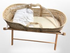 A wicker crib on folding stand, length 85cm.