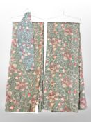 A pair of floral curtains with tiebacks.