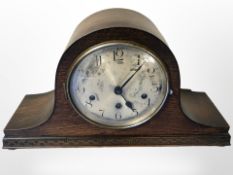 An early-20th century oak eight day mantel clock with silvered dial, width 42cm.
