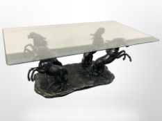 A contemporary glass and composition coffee table with rearing horse support,