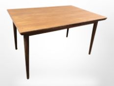 A Danish teak pull out extending dining table on splayed tapering legs,