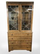 A 1930's oak and leaded glass bookcase, fitted drawers beneath. 106cm w x 43 d x 205 h.
