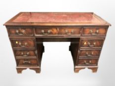 A reproduction mahogany nine drawer pedestal desk, with leather inset writing surface,