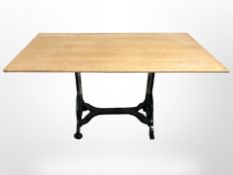 An oak topped dining table on cast iron support,
