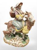 A Pearl ware figure group, circa 1800, modelled as a lady and two babies atop a large goat,