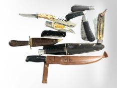 A group of folding pocket knives, two hunting knives in sheaths, etc.