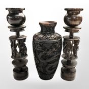 A pair of African carved hardwood figural candlesticks, height 27cm, and a modern Thai resin vase.