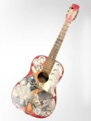 A vintage acoustic guitar with later The Beatles decals.