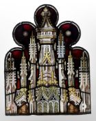 A stained glass ogee panel, decorated with Gothic columns against a red backdrop, 79cm by 61cm.
