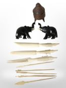 A pair of African carved ebony elephants, a group of bone cutlery and a wooden sifter.