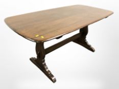 An Ercol stained elm 5' dining table and a set of four spindle back chairs.