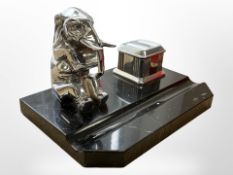 An Art Deco chrome and black marble desk stand surmounted by an elephant and inkwell, width 21cm.