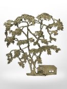 A cast-brass ornament of a tree by a cabin, height 39cm.