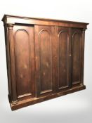 A late Victorian oak four door compactum wardrobe, 233cm w x 63cm d x 205cm h.