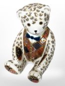A Royal Crown Derby seated teddy bear paperweight with silver stopper, height 12cm.