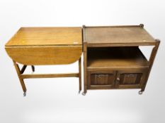 An oak linen fold two-tier serving trolley and a further drop leaf table