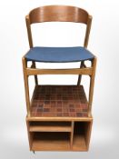 A Danish teak framed chair and a tiled topped low table on castors,