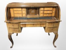 An early-20th century Scandinavian walnut cylinder front writing bureau on cabriole legs,
