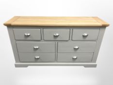 A modern oak and MDF painted seven drawer sideboard, 141cm x 43cm x 77cm.