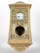 A reproduction continental heavily carved oak eight day wall clock, with pendulum and two keys,